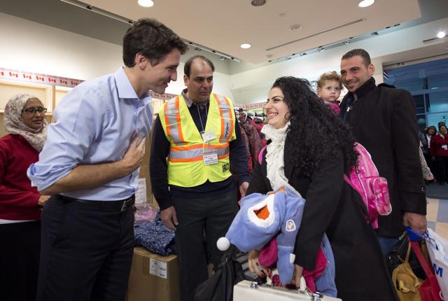 Canadian PM Justin Trudeau (L) greets Georgina Zires, Madeleine Jamkossian and her father Kevork Jamkossian -- refugees fleeing from Syria -- as they arrive at the Pearson International airport, in Toronto. (The Canadian Press via AP )