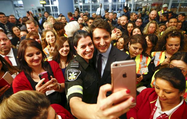 Canada's Prime Minister Justin Trudeau poses with airport staff as they await Syrian refugees arriving at the Toronto Pearson International Airport in Mississauga, Ontario. (Reuters )