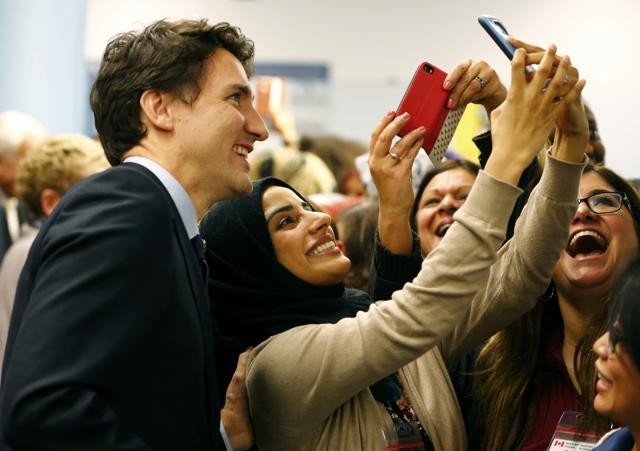 Canada's Prime Minister Justin Trudeau (L) poses with airport staff as they await Syrian refugees to arrive at the Toronto Pearson International Airport in Mississauga, Ontario. (REUTERS) Canada's Prime Minister Justin Trudeau (L) poses with airport staff as they await Syrian refugees to arrive at the Toronto Pearson International Airport in Mississauga, Ontario. (REUTERS)