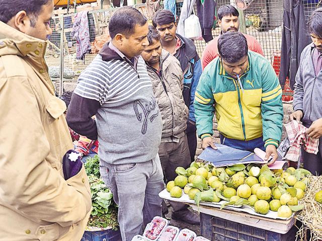 Officials issuing challans after discovering vendors using plastic bags in Sector 26 , Chandigarh.(Karun Sharma/HT Photo)