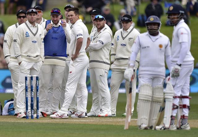 Rangana Herath of Sri Lanka watches the DRS screen, after challenging a LBW call, as team mate Milinda Siriwardana, and the New Zealand team look on during day three of the first International Test cricket match between New Zealand and Sri Lanka at New Zealand's University Oval in Dunedin on December 12, 2015. (AFP Photo)