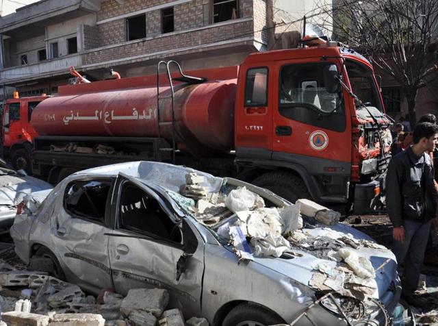 A firefighter truck is seen next to a destroyed car at the site of a car bomb explosion in al-Zahra neighborhood in Homs. (AFP) A firefighter truck is seen next to a destroyed car at the site of a car bomb explosion in al-Zahra neighborhood in Homs. (AFP)