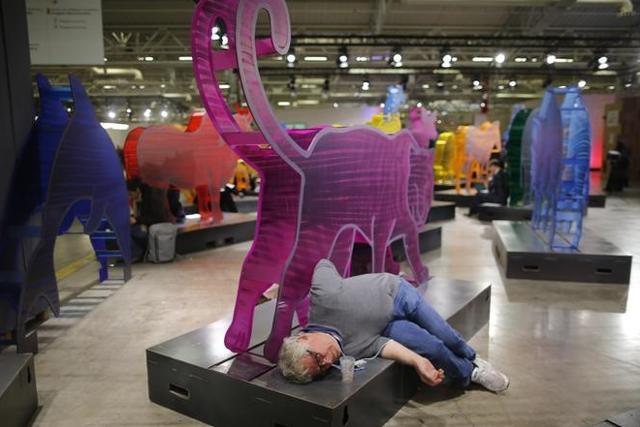 A participant rests under an animal figure at the World Climate Change Conference 2015 (COP21) at Le Bourget, near Paris, France, December 12, 2015. (Reuters)