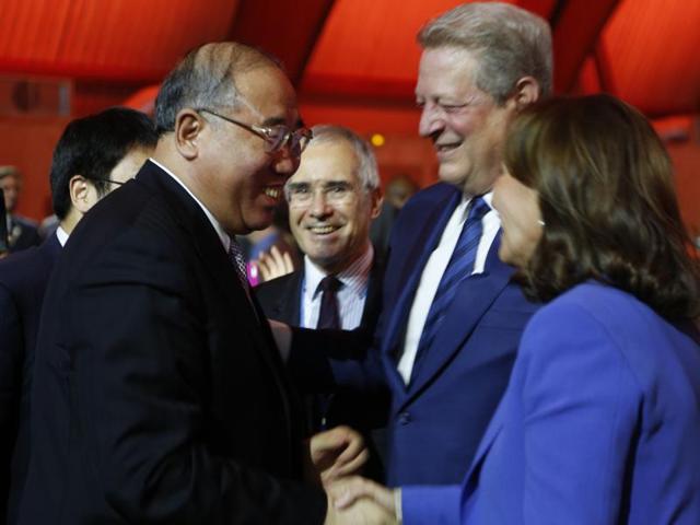 French President Francois Hollande (C) embraces Christiana Figueres, Executive Secretary of the UN Framework Convention on Climate Change, as United Nations Secretary-General Ban Ki-moon (R) looks on at the final plenary session at the World Climate Change Conference 2015 (COP21) at Le Bourget, near Paris, France, December 12, 2015.(Reuters)