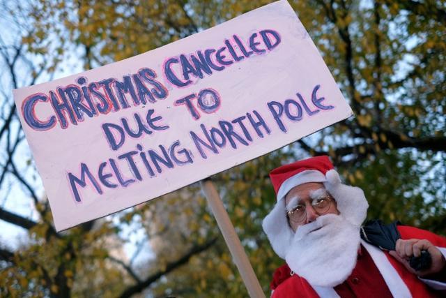 A man dressed as Santa Claus displays a placard during a rally calling for action on climate change in New York. (AFP) A man dressed as Santa Claus displays a placard during a rally calling for action on climate change in New York. (AFP)