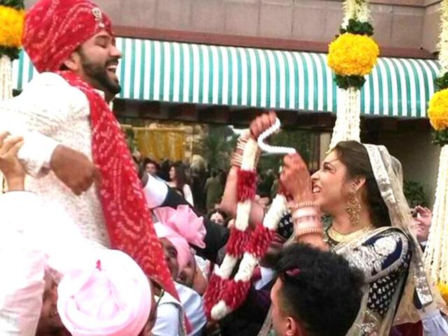 Last chance to escape: During the playful varmala ceremony, Ritika tries to get hold of Rohit lifted by his friends. (Twitter)