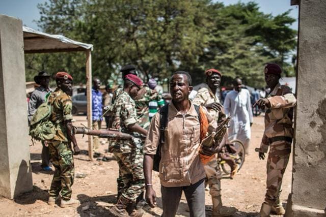 A member of the Muslim auto defence group of the flashpoint PK5 district in Bangui carries RPG ammunitions as he walks by Central African Armed forces soldiers to secure the voting operations at the Koudoukou school. (AFP Photo) A member of the Muslim auto defence group of the flashpoint PK5 district in Bangui carries RPG ammunitions as he walks by Central African Armed forces soldiers to secure the voting operations at the Koudoukou school. (AFP Photo)