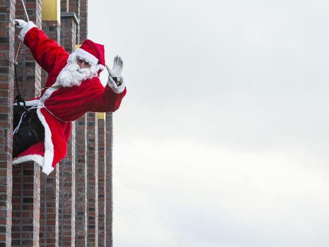 A man dressed as Father Christmas aka Santa Claus climbs down the Kollhoff tower on December 13, 2015 as part of a yearly stunt before the festive season. (AFP)