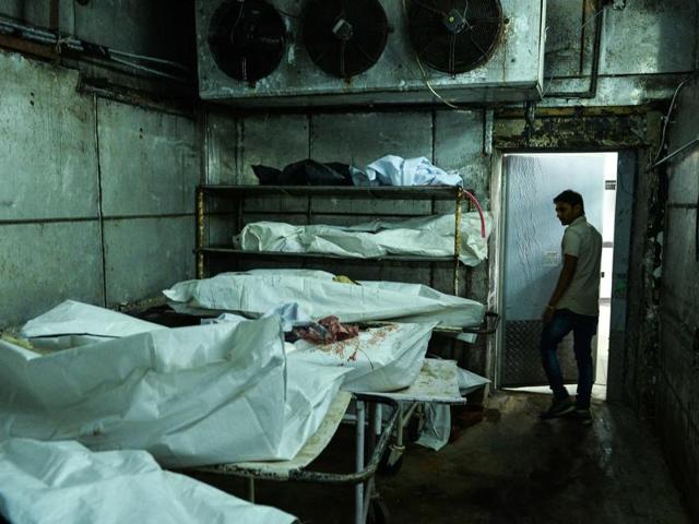 A medic walks through a cold storage unit as he inspects a morgue in New Delhi. Inside the cold storage rooms, bodies take up every square inch of the blood-stained floors. (AFP Photo) A medic walks through a cold storage unit as he inspects a morgue in New Delhi. Inside the cold storage rooms, bodies take up every square inch of the blood-stained floors. (AFP Photo)