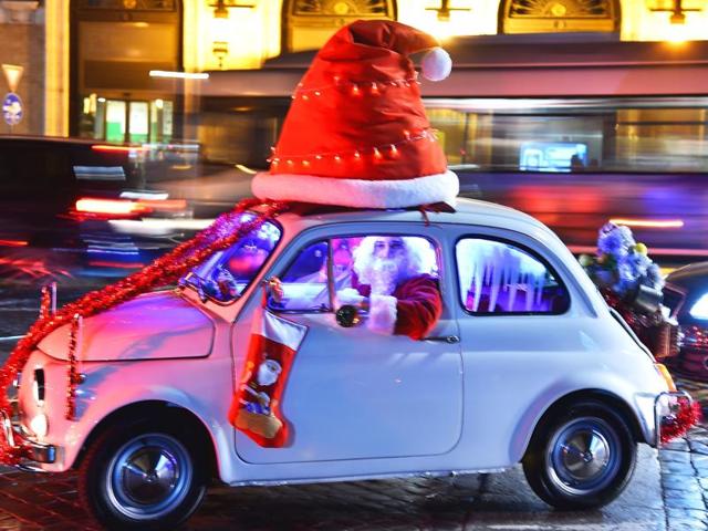A man dressed as Santa Claus drives an old Fiat 500 car at Piazza Venezia square in central Rome on December 13, 2015. (AFP)