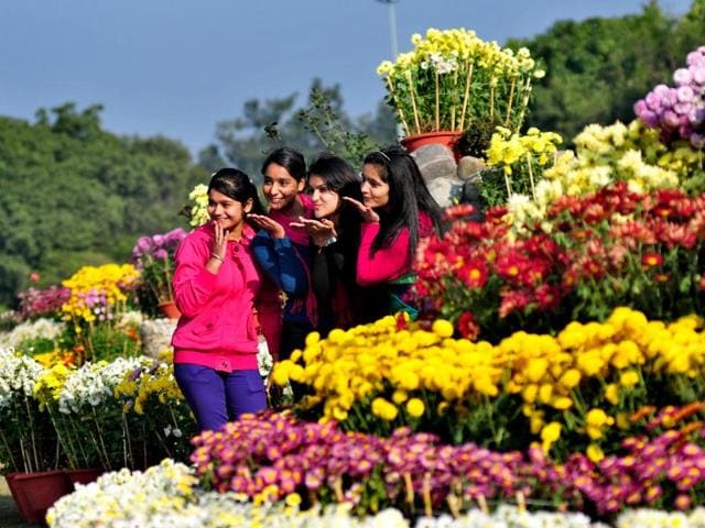 Girls pose for a picture as they soak in the festivities at the Chrysanthemum Show being held at the Panjab University in Chandigarh. (Ravi Kumar/HT Photo)