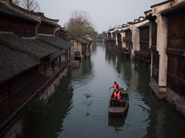 Canal cleaners go about their chores in Wuzhen in China's Zhejiang province, where the World Internet Conference takes place, at dawn on December 16, 2015. Ancient stone bridges, stone pathways and delicate wood carvings are reminiscent of Wuzhen’s legacy. (AFP) Canal cleaners go about their chores in Wuzhen in China's Zhejiang province, where the World Internet Conference takes place, at dawn on December 16, 2015. Ancient stone bridges, stone pathways and delicate wood carvings are reminiscent of Wuzhen’s legacy. (AFP)