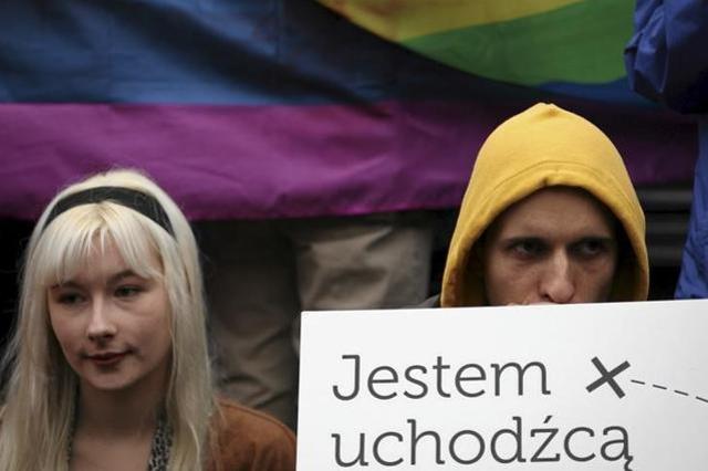 A protester holds a sign which reads "I am a refugee" during a demonstration to welcome refugees in front of the Nicolaus Copernicus monument in Warsaw, Poland. Many refugees are supported only by non-profit organisations that offer language lessons or help them overcome administrative hurdles after they leave the centres. A protester holds a sign which reads "I am a refugee" during a demonstration to welcome refugees in front of the Nicolaus Copernicus monument in Warsaw, Poland. Many refugees are supported only by non-profit organisations that offer language lessons or help them overcome administrative hurdles after they leave the centres.