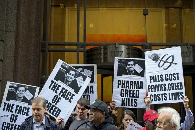 Activists hold signs containing the image of Turing Pharmaceuticals CEO Martin Shkreli in front the building that houses Turing's offices, in New York, during a protest highlighting pharmaceutical&nbsp;drug pricing. (AP)