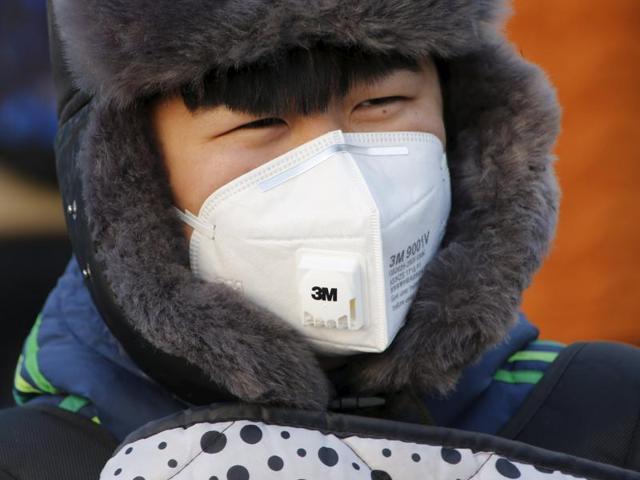 A man wears a protective mask makes her way as China warned residents across a large part of northern China to prepare for a wave of choking smog arriving over the weekend, in Beijing, China.(REUTERS)