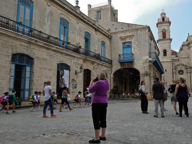 Tourists visit the Old Havana on December 16, 2015. Crowds of foreign tourists walk at the historical centre of Havana while Cuban migrants mass at refuges in Costa Rica on their way to the US. When Cuba and the US announced a year ago that they would end five decades of enmity, few imagined the double effect this would produce. (AFP)