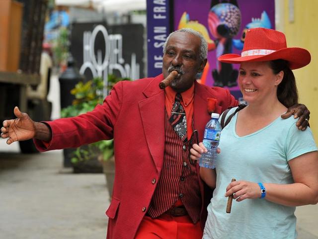 A tourist poses with a Cuban man as she visits the Old Havana on December 16, 2015. (AFP)