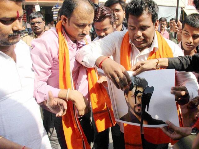 Hindu Rashtriya Sena activists blacken a poster of Shah Rukh Khan during a protest against the screening of his film Dilwale near a mall in Mumbai on Friday. (PTI)