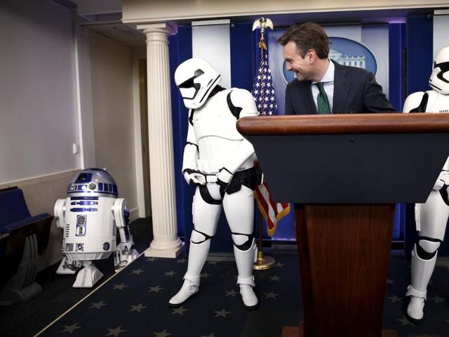 White House press secretary Josh Earnest and Star Wars Stormtroopers wait for R2-D2 to enter the briefing room after US President Barack Obama finished his end of the year news conference at the White House. (REUTERS)