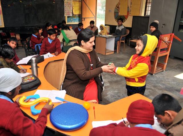 An inclusive education volunteer teaching children with special needs at resource centre, Abadpura, in Jalandhar on Friday.(HT Photo)