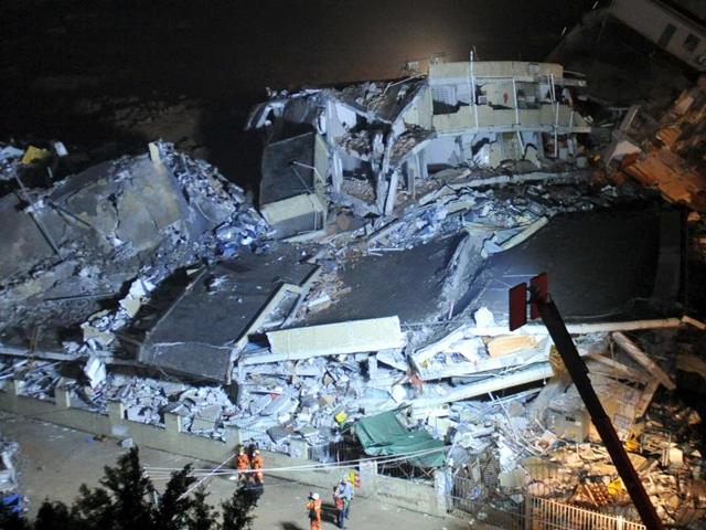 Firefighters stand next to collapsed buildings after a landslide hit an industrial park in Shenzhen, Guangdong province, China.(Reuters Photo)