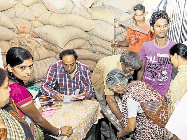 People purchase food grains distributed by a public distribution system shop in Ranchi on Sunday.(Diwakar Prasad/HT photo)