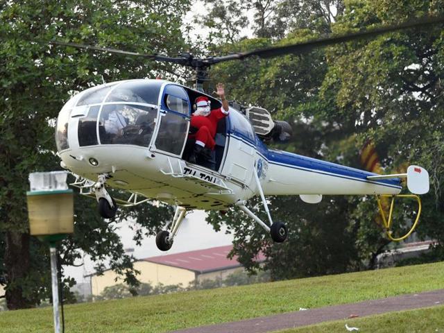 Santa Claus arrives in a helicopter in the garden of the presidential palace in Abidjan distribute gifts to 3000 children during a Christmas event organised by the Fondation Children of Africa. The event was organised by Ivory Coast's first lady Dominique Ouattara. (AFP) Santa Claus arrives in a helicopter in the garden of the presidential palace in Abidjan distribute gifts to 3000 children during a Christmas event organised by the Fondation Children of Africa. The event was organised by Ivory Coast's first lady Dominique Ouattara. (AFP)