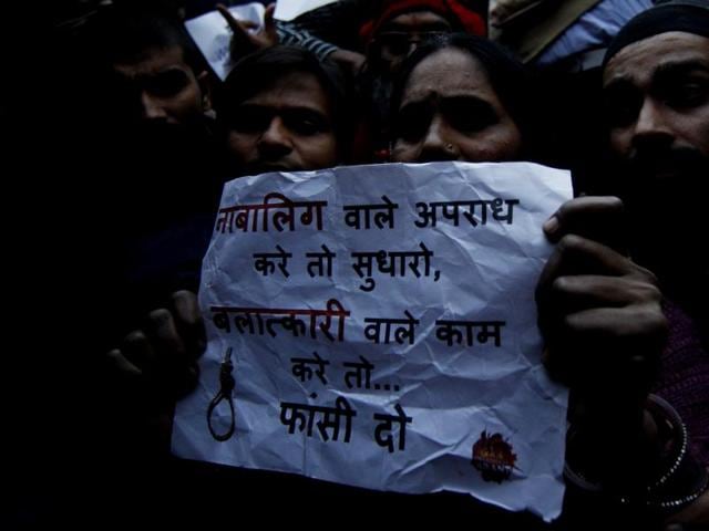 The victim’s mother holds a poster while protesting at India Gate, in New Delhi. (Ravi Choudhary/HT Photo)