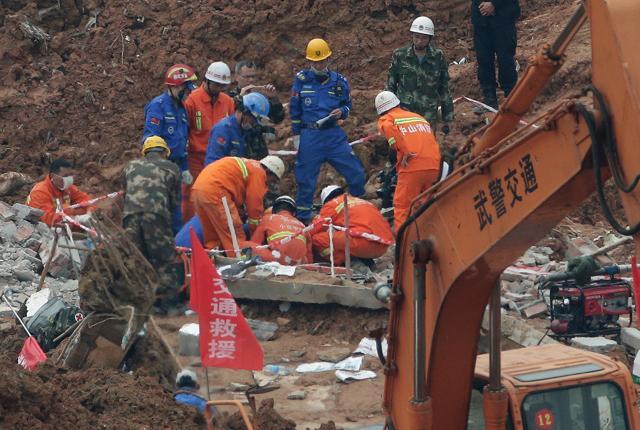 Rescuers try to get into a buried building to search for potential survivors following the landslide. (AP photo)