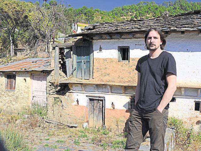 Jeroen in front of a dilapidated house at Badoli village in Pauri district.(Arvind Moudgil/HT photo)