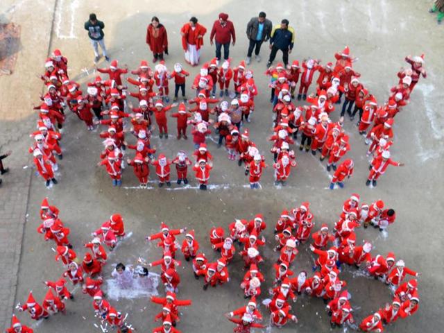 Little Santa Clauses gather to form a ‘Merry XMas’ sign during celebrations in Amritsar on Wednesday. (Sameer Sehgal / HT Photo) 