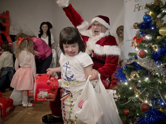 Eight years old Maia laughs walking away with presents received from a man dressed as Santa Claus during a Christmas party for children affected by the Down Syndrome, organized by the Angels Down Friends association in Bucharest, Romania. (AP) Eight years old Maia laughs walking away with presents received from a man dressed as Santa Claus during a Christmas party for children affected by the Down Syndrome, organized by the Angels Down Friends association in Bucharest, Romania. (AP)