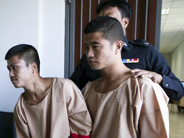 Myanmar migrants Win Zaw Htun, right, and Zaw Lin, left, both 22, are escorted by officials after their guilty verdict at court in Koh Samui, Thailand.(AP Photo)