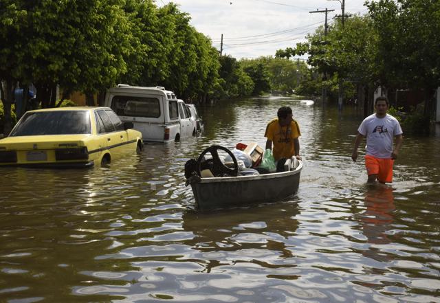 Locals attempt to recover belongings at a flooded neighbourhood in Paraguay’s capital, Asuncion on December 24, 2015. (AFP Photo) Locals attempt to recover belongings at a flooded neighbourhood in Paraguay’s capital, Asuncion on December 24, 2015. (AFP Photo)