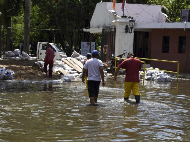 Locals recover belongings from a flooded neighbourhood in Asuncion on December 24, 2015. Constant and heavy rains in the country have caused the overflowing of the Paraguay river, forcing 150,000 to evacuate. (AFP Photo) Locals recover belongings from a flooded neighbourhood in Asuncion on December 24, 2015. Constant and heavy rains in the country have caused the overflowing of the Paraguay river, forcing 150,000 to evacuate. (AFP Photo)