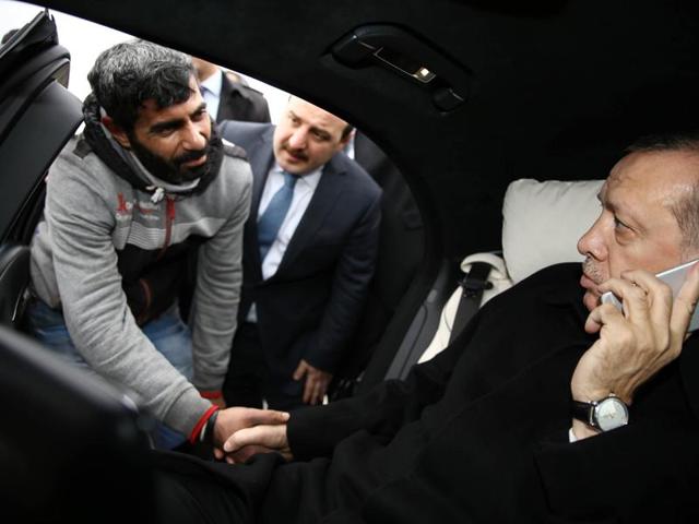 Turkish President Recep Tayyip Erdogan (R) shakes hands with a man who was allegedly about to attempt suicide off the Bosporus bridge in Istanbul.(AFP)