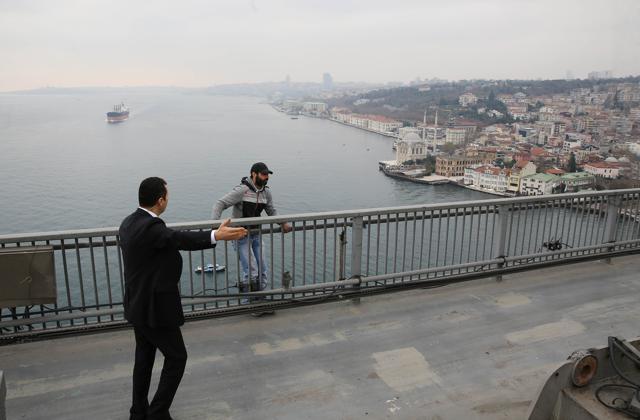 A security guard, part of Turkish President Recep Tayyip Erdogan security detail, speaks to a man standing behind of the Bosporus bridge barrier in Istanbu. (AFP) A security guard, part of Turkish President Recep Tayyip Erdogan security detail, speaks to a man standing behind of the Bosporus bridge barrier in Istanbu. (AFP)