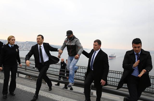 Security guards, part of Turkish President Recep Tayyip Erdogan security detail, escort a man from behind the barrier of the Bosporus bridge in Istanbul. (AFP) Security guards, part of Turkish President Recep Tayyip Erdogan security detail, escort a man from behind the barrier of the Bosporus bridge in Istanbul. (AFP)