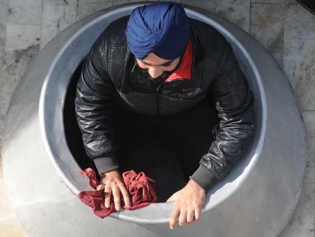 Sikh devotee cleans big utensil in preparation for the langar at Fatehgarh Sahib on the occasion of the 311th Sheede Jor Mel. (Bharat Bhushan/HT Photo)
