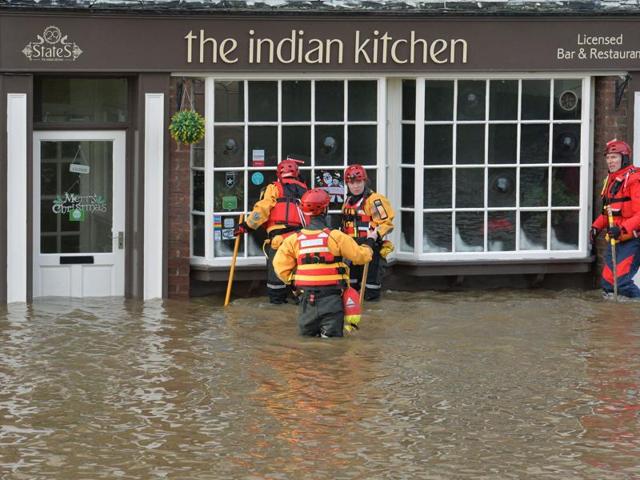 Members of the Mountain Rescue team stand over kneed deep in water outside a property, after floods, in Tower Street, York.(AP) Members of the Mountain Rescue team stand over kneed deep in water outside a property, after floods, in Tower Street, York.(AP)