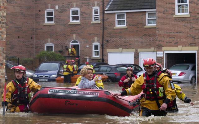 A woman is taken to safety in a dinghy by members of the emergency services, after homes were affected by floodwaters in streets close to The River Foss after it burst it's banks in York. (AFP) A woman is taken to safety in a dinghy by members of the emergency services, after homes were affected by floodwaters in streets close to The River Foss after it burst it's banks in York. (AFP)