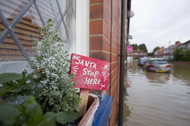 A "Santa Stop Here" sign is pictured in a window box on a house in a flooded residential street next to the River Foss after it burst it's banks in York. (AFP) A "Santa Stop Here" sign is pictured in a window box on a house in a flooded residential street next to the River Foss after it burst it's banks in York. (AFP)