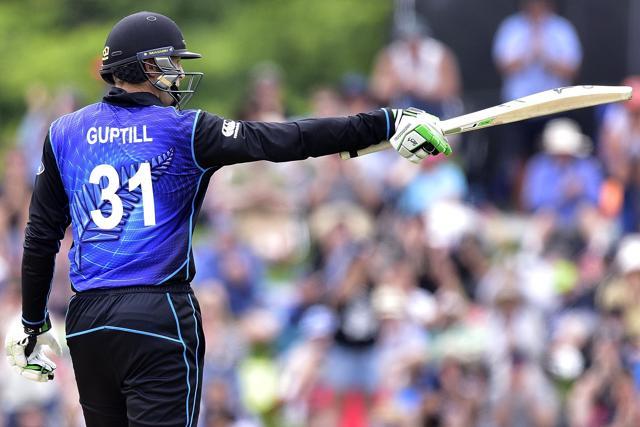 Martin Guptill raises his bat in celebration of his 50, the fastest by a New Zealand batsman. (AFP Photo)