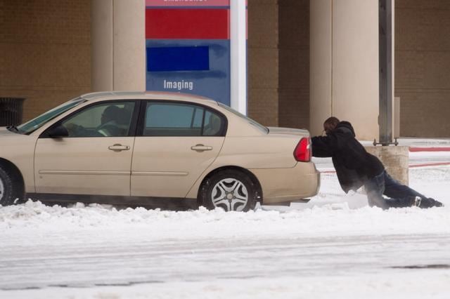 A driver receives a helpful push to escape from a snow drift in Lubbock, Texas. (AFP photo) A driver receives a helpful push to escape from a snow drift in Lubbock, Texas. (AFP photo)