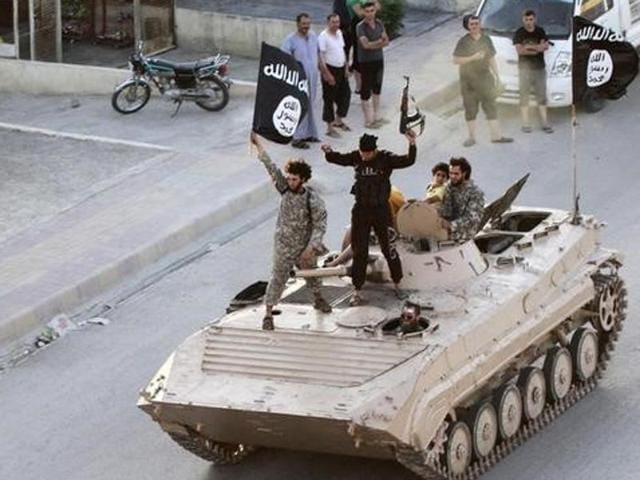 Militant Islamist fighters hold the flag of Islamic State (IS) while taking part in a military parade along the streets of northern Raqqa province in this June 30, 2014 file photo. IS has set up departments to handle “war spoils,” creating the trappings of government that enable it to (Reuters File Photo) Militant Islamist fighters hold the flag of Islamic State (IS) while taking part in a military parade along the streets of northern Raqqa province in this June 30, 2014 file photo. IS has set up departments to handle “war spoils,” creating the trappings of government that enable it to (Reuters File Photo)
