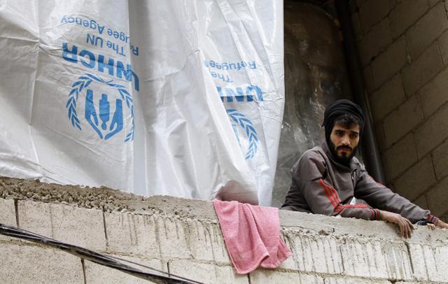 A Syrian man looks on from inside an unfinished building where he lives with his family. (AFP) A Syrian man looks on from inside an unfinished building where he lives with his family. (AFP)