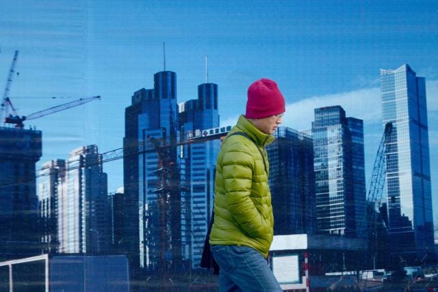 A man walks past a billboard in Beijing. Only 10% of migrants have bought a home in the places they have moved to, according to the World Bank. (AFP) A man walks past a billboard in Beijing. Only 10% of migrants have bought a home in the places they have moved to, according to the World Bank. (AFP)
