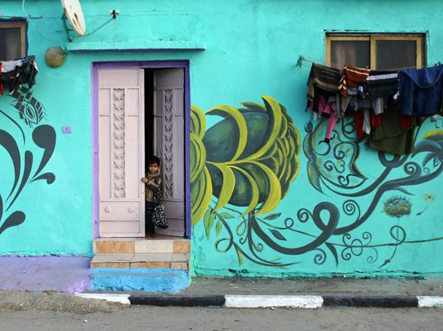 A Palestinian child looks out of a house painted by Palestinian artists in the al-Shati refugee camp in Gaza City, on December 19. (AFP)
