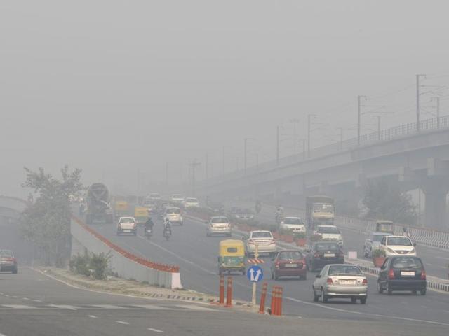 Office-goers found it difficult to travel in Delhi roads after thick smog engulfed the city . (Photo by Mohd Zakir/ Hindustan Times) (Hindustan Times)