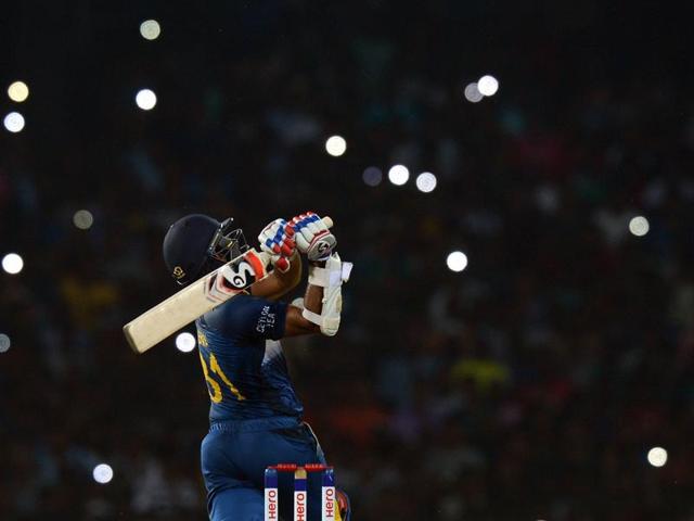 Sri Lankan cricketer Shehan Jayasuriya plays a shot as light from spectators' mobile phones are seen in the background during the second T20 match against the West Indies at the R Premadasa Stadium in Colombo on November 11, 2015. (AFP Photo) 
